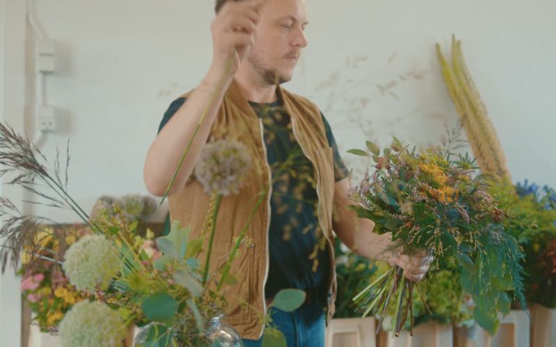 Medarbejder fra Folium står med blomster og laver buket